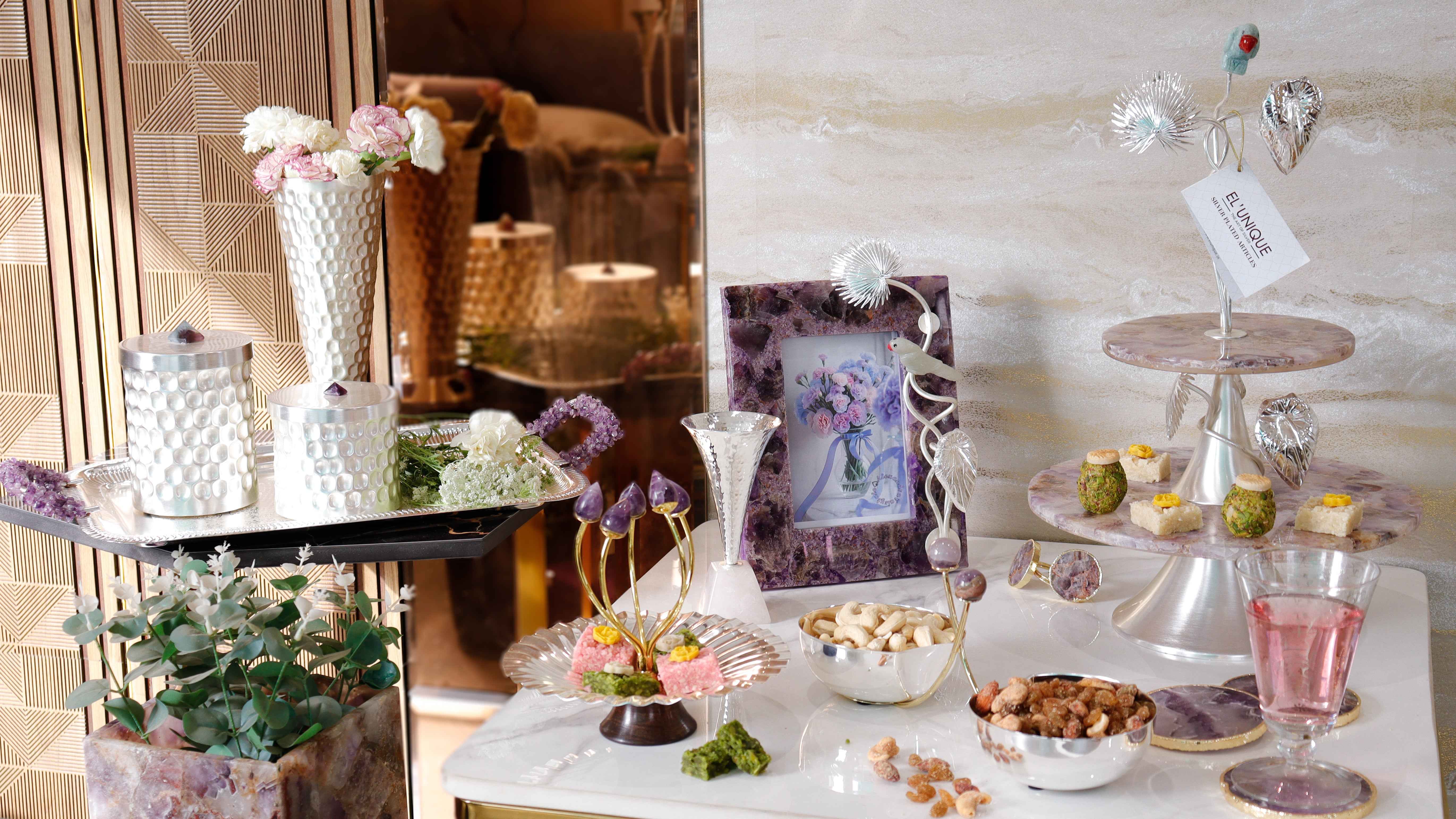 Luxury handcrafted amethyst and silver home décor table setup by El Unique featuring decorative trays, vases, photo frames, dry fruit bowls, candle holders and premium serving stands.